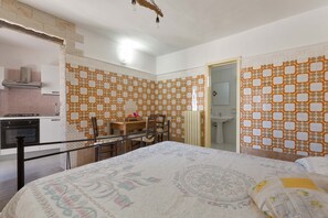 A bedroom with a bed, a wooden desk, and a chair. There is a bathroom with a sink and a toilet visible through an open door. - 2432 Tenuta Fioravante - Bilo Antonia by Barbarhouse (Porto Cesareo)