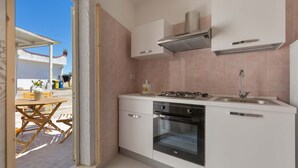 A modern kitchen with white cabinets, a gas stove, an oven, and a sink. - 2432 Tenuta Fioravante - Bilo Antonia by Barbarhouse (Porto Cesareo)