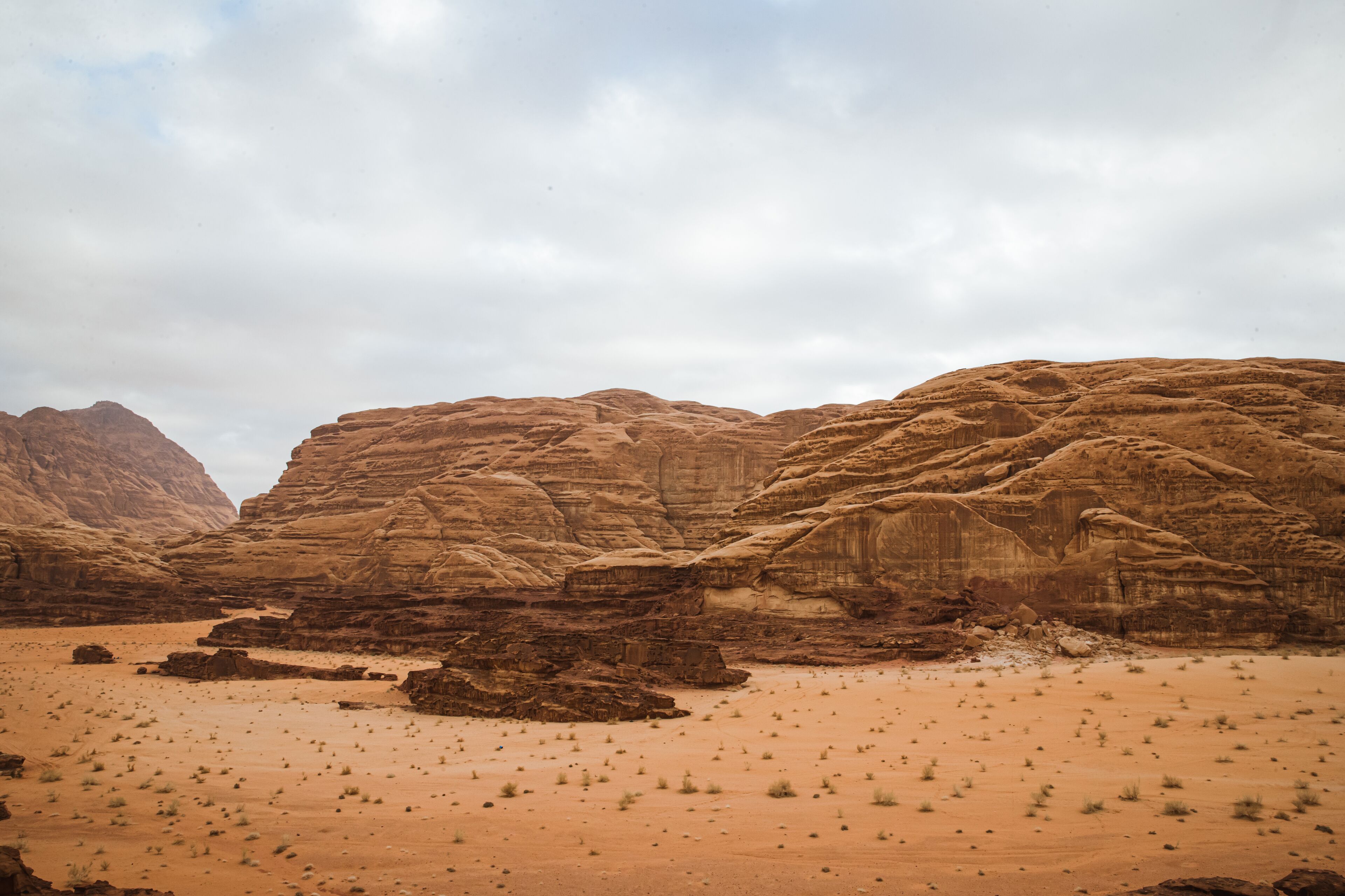 A desert landscape with rocky formations and sparse vegetation.