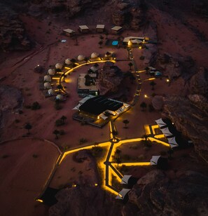 An aerial view of a resort with a central building, guest rooms, and a winding pathway. - Palmera Camp Wadi Rum (Wadi Rum)