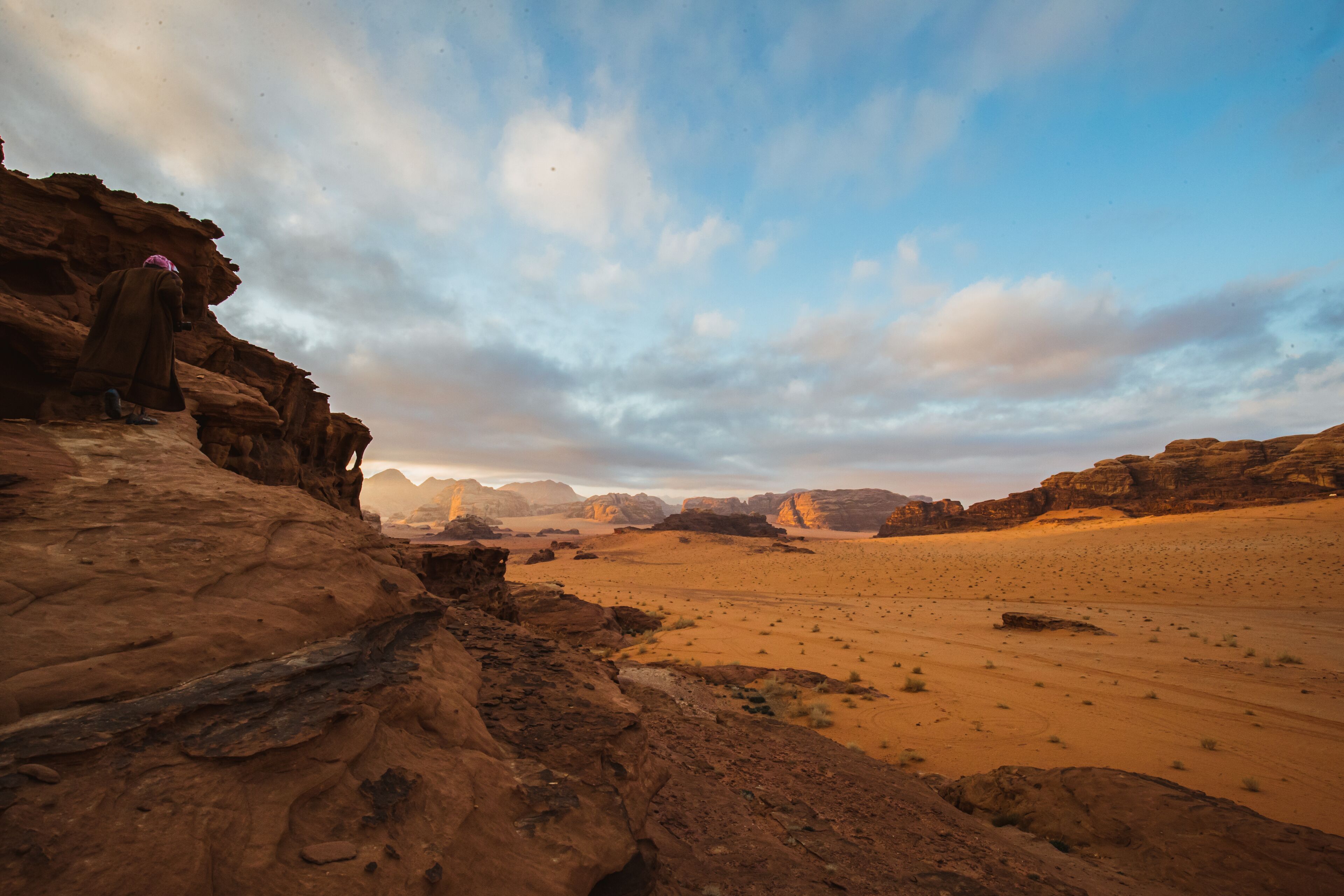 A desert landscape with rocky terrain and distant mountains.