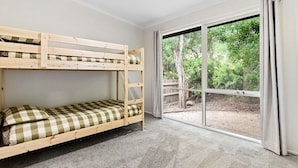 A bunk bed room with a large window and a view of greenery outside. - The back ultimate beach family, couples, girls trip or golf trip stay. (Blairgowrie)