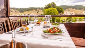 A table set for dining with a view of the countryside.