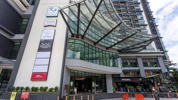 Um edifício moderno com vários sinais indicando Vista Residence, Le Vert, Brew House e JSI Express.