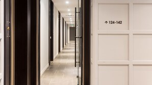 Corredor de hotel com placa indicando os quartos 124 a 142.