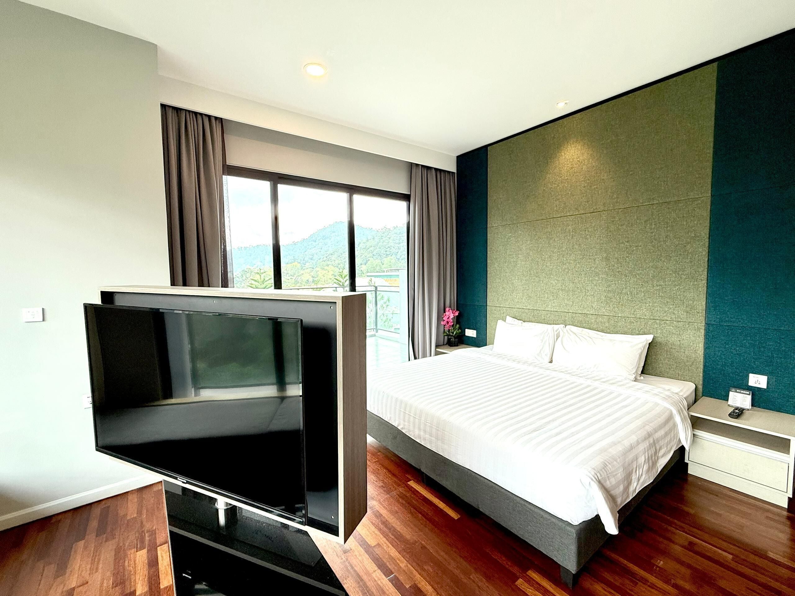 Habitación de hotel moderna con una cama grande, televisión de pantalla plana y vistas al exterior.