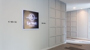 Um corredor de hotel com um letreiro de neon para o Le Vert Boutique Hotel.