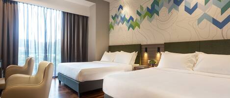 A hotel room with two beds, a desk, and a chair.