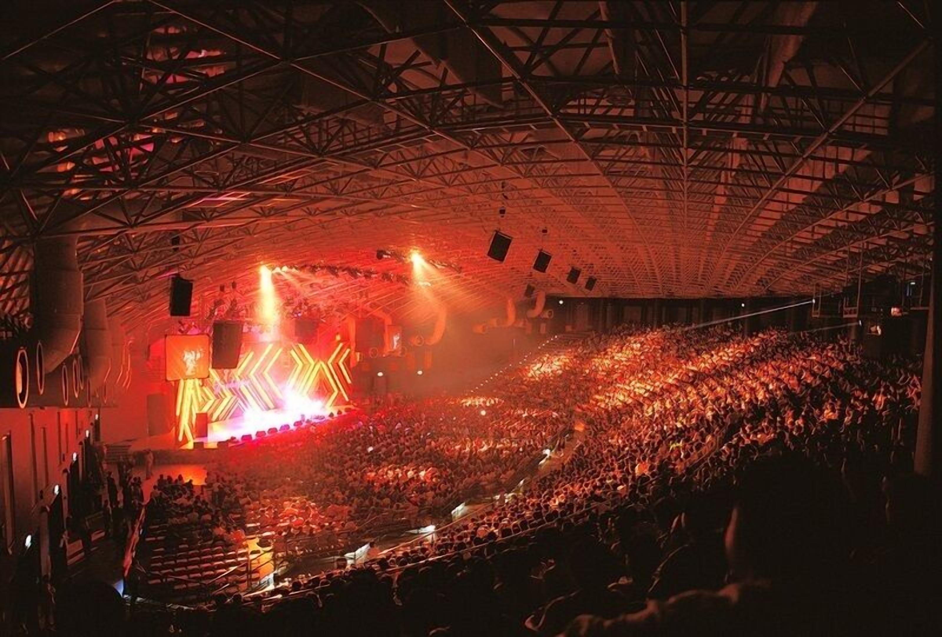 A large indoor venue with a high ceiling and a stage at the front.