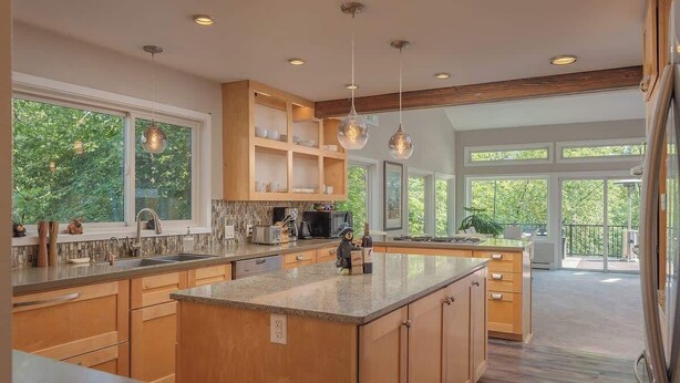 A spacious kitchen with wooden cabinets, a large island, and pendant lighting. - The Downtown Anchorage Grand Four Bedroom (Anchorage)