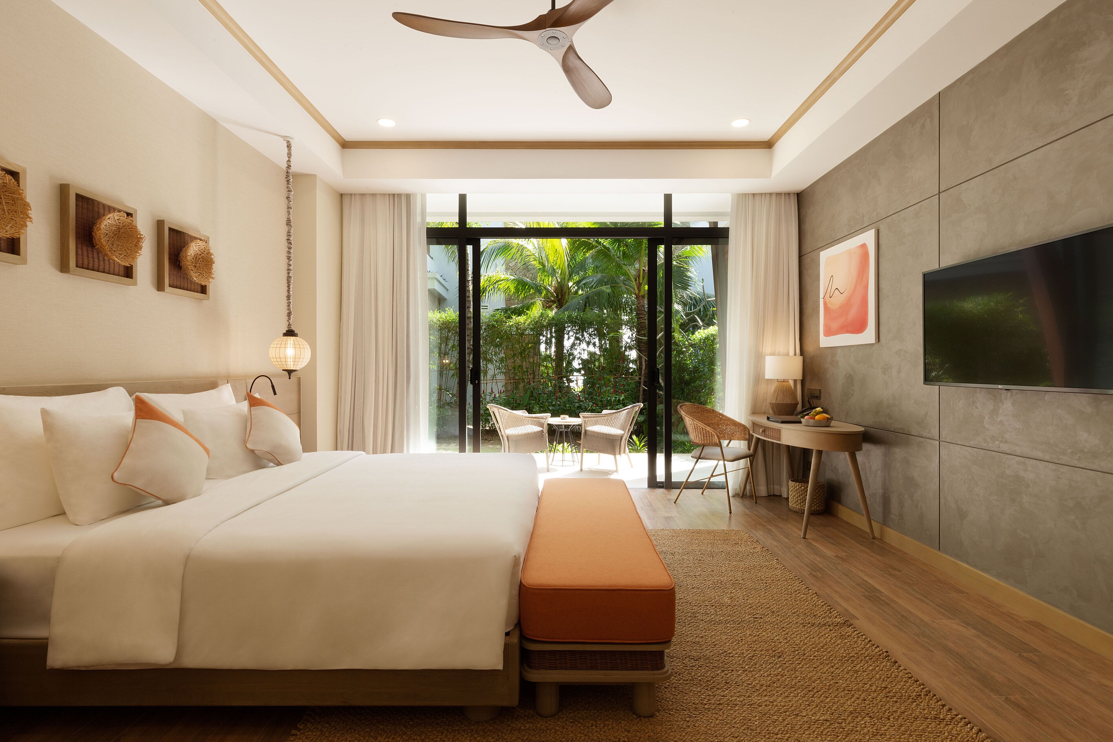 A modern hotel room with a large bed, a desk, and a television.