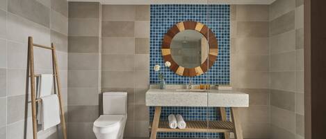 A bathroom with a toilet, sink, wooden ladder, and a mirror with a wooden frame.