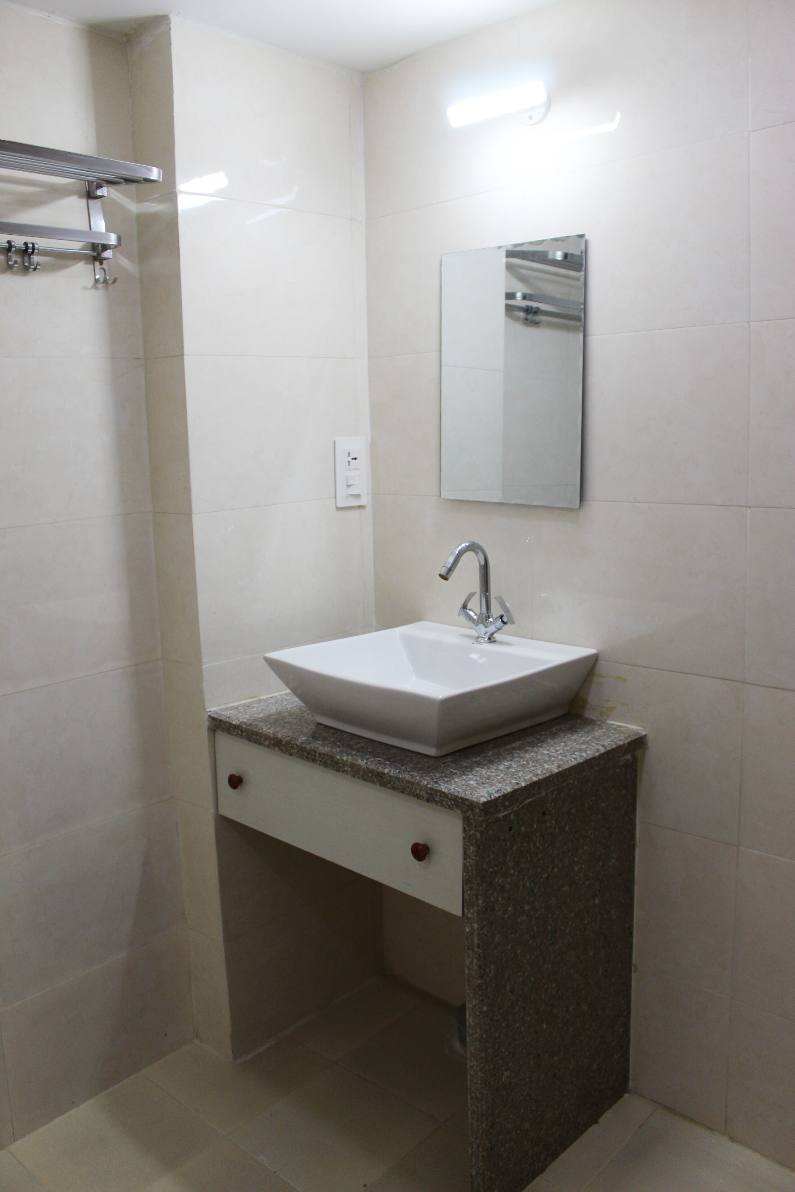 A bathroom with a white sink, a mirror, and a towel rack.