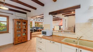 Una cocina con armarios de madera, un microondas y un lavabo.