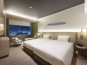 Ein modernes Hotelzimmer mit einem großen Bett, einer Sitzecke, Blick auf die Stadt und einem außergewöhnlichen Deckenstil.