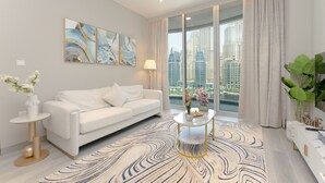 A modern living room with a white sofa, a coffee table, and a view of tall buildings through large windows. - Marvelous Apartments in Business Bay (Dubai)