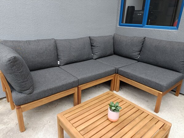 Relax on a comfortable L-shaped sofa in a cozy outdoor space.