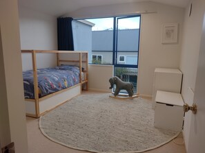 Cozy bedroom with a bunk bed, featuring a colorful mattress, and a charming elephant-shaped toy.