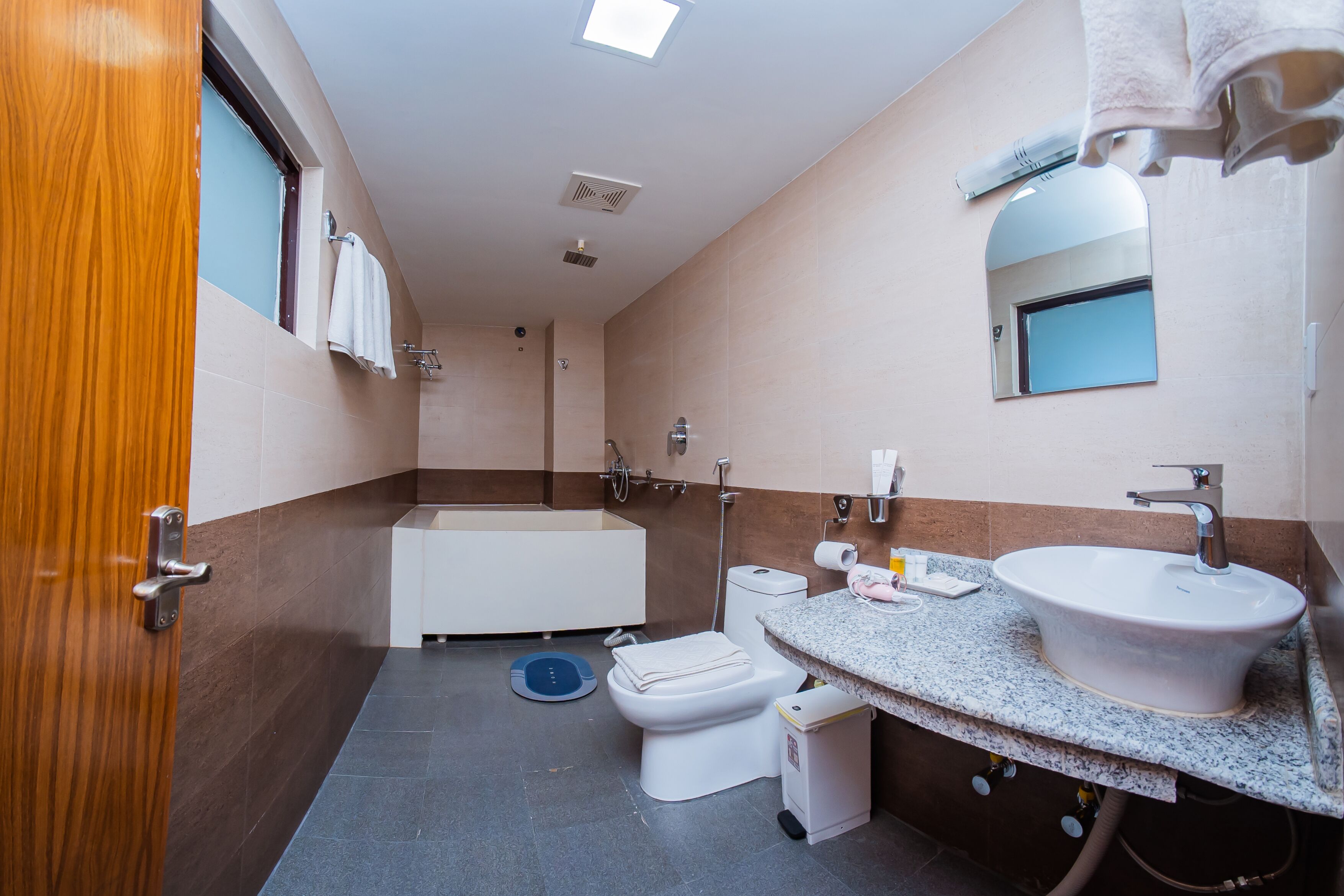 A modern bathroom with a bathtub, toilet, and sink.