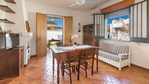 A dining area with a wooden table and chairs, a sofa, and a ceiling fan. - 2753 Villa Evelin by Barbarhouse (Porto Cesareo)