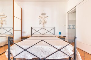 A bedroom with a bed, nightstands, a mirror, and a chandelier. - 2753 Villa Evelin by Barbarhouse (Porto Cesareo)