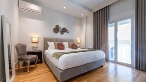 Une chambre d’hôtel moderne, dotée d’un grand lit, d’une chaise, d’une table de chevet et d’une lampe fixée au mur.