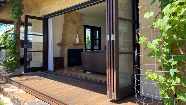 A modern house with a glass door leading to a living area with a fireplace. - Luxury family haven (OCEAN GROVE)