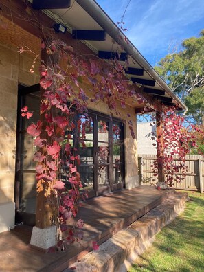 A house with a covered porch, stone walls, and a wooden deck. - Luxury family haven (OCEAN GROVE)
