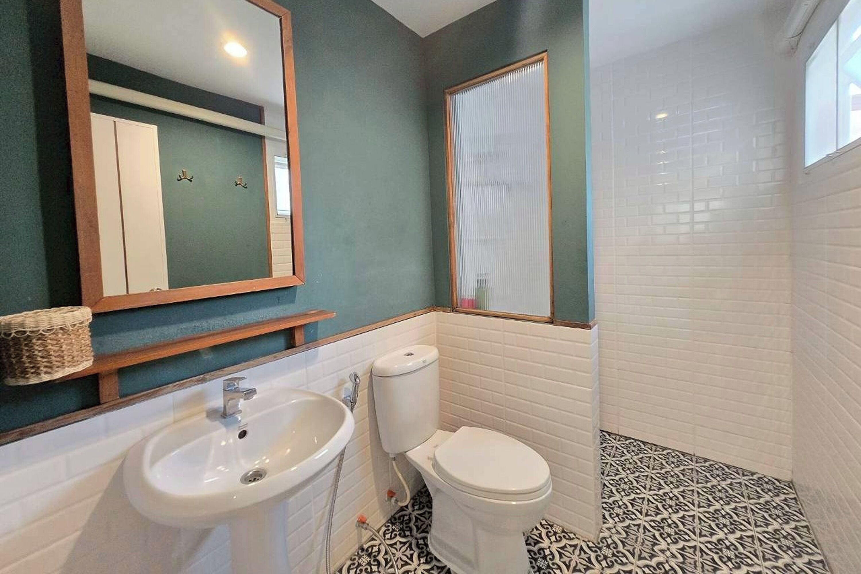 A bathroom with a sink, toilet, and a mirror.