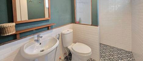 A bathroom with a sink, toilet, and a mirror.