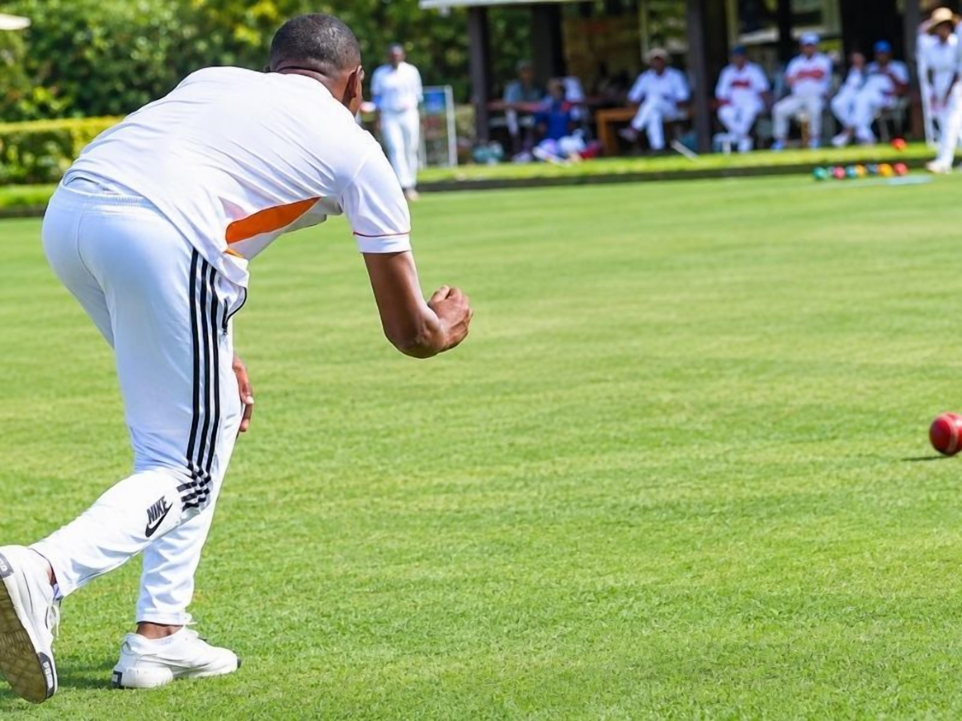 A person in sports attire on a grassy field, possibly playing a game.