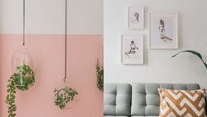 Una habitación con un sofá gris, un cojín estampado y tres cuadros en la pared.