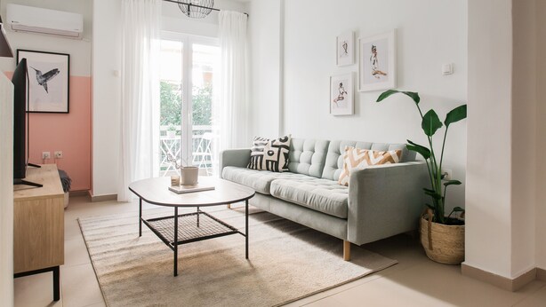 Una sala de estar moderna con un sofá, una mesa de centro y una planta en maceta.