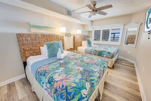 A bedroom with two beds, a ceiling fan, and a large window with blinds. - WOW Newly Updated Ocean Front Condo with New Pools (North Myrtle Beach)