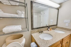 A bathroom with two sinks, a large mirror, and a towel rack with towels. - WOW Newly Updated Ocean Front Condo with New Pools (North Myrtle Beach)
