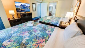 A hotel room with two beds, a TV, a desk, and a bathroom visible through an open door. - 1BR Oceanview at Carolinian, Pools, Amazing Views! (Myrtle Beach)