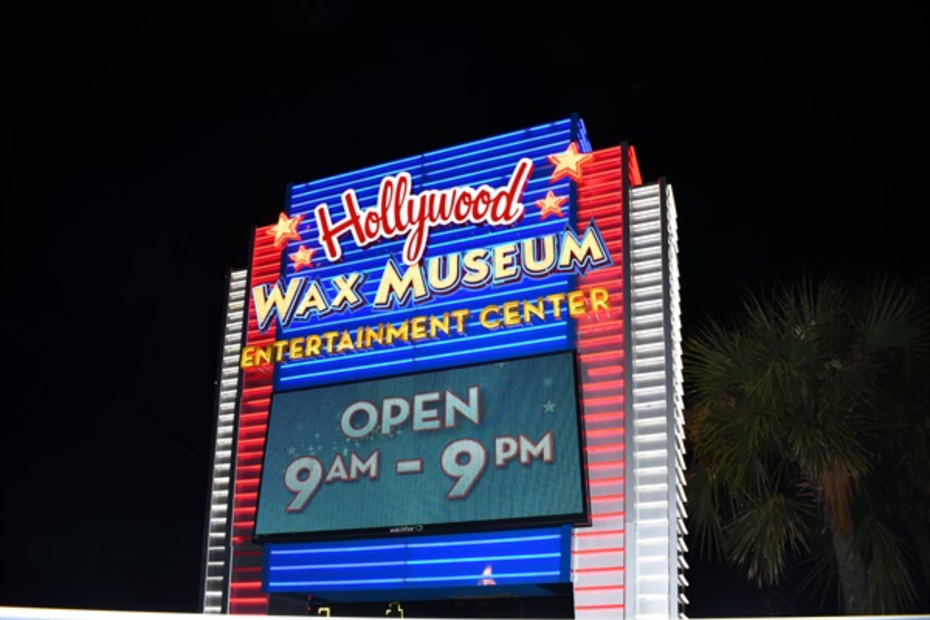 A sign for the Hollywood Wax Museum with the text "OPEN 9AM - 9PM".