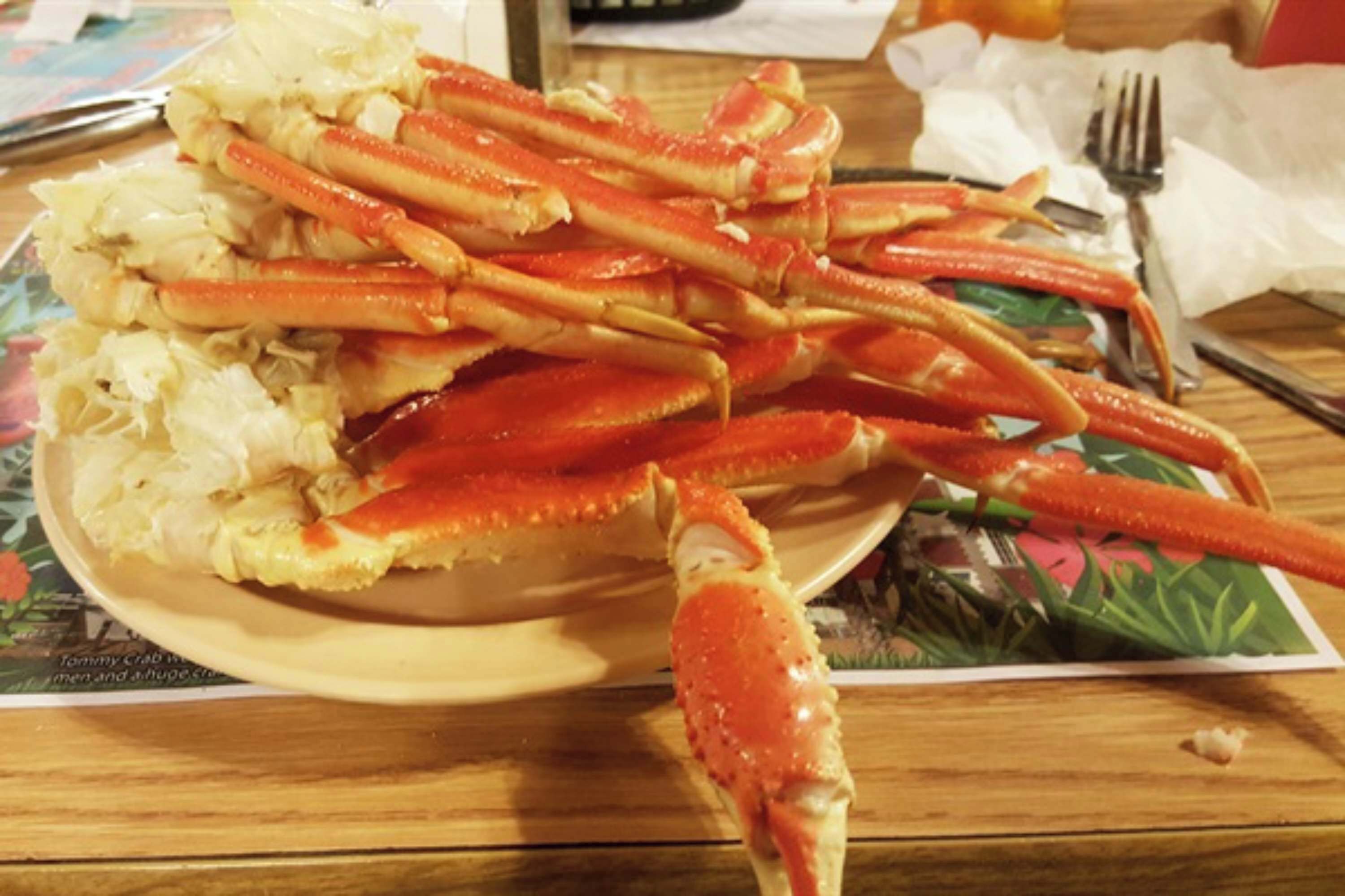 Une assiette de pattes de crabe cuites, posée sur une table.
