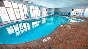 An indoor swimming pool with clear blue water, surrounded by a brick floor and large windows. - Oceanfront View w/ Beach Access at Sea Mist Resort (Myrtle Beach)