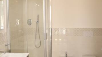 Regadera, secadora de cabello, bidet, toallas