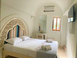 Relax in a stylish bedroom with a large bed, bedside table, and flat-screen TV.