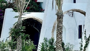 Un bâtiment blanc avec un toit bleu et une grande entrée en arc de cercle.