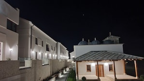 A modern hotel with a central courtyard, a covered outdoor seating area, and a pool. - Kalima resort (Mostar)