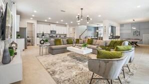 A spacious living room with a sofa set, a coffee table, and a dining area.