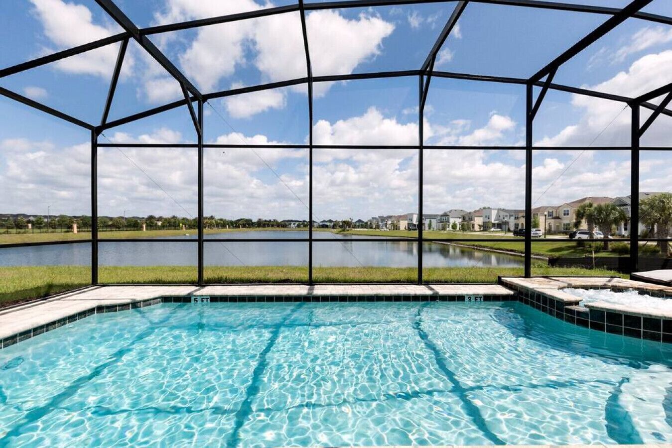 Une piscine offrant une vue dégagée sur un lac et des immeubles résidentiels en arrière-plan.