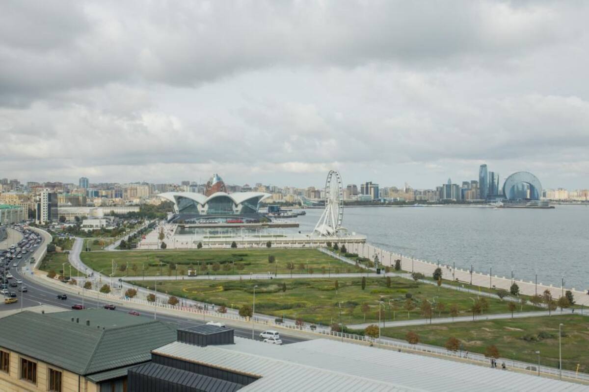 A cityscape with a river, a Ferris wheel, and modern architecture.