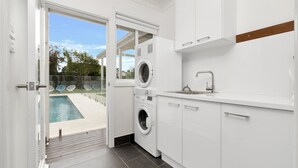 Eine moderne Küche mit integrierten Geräten, einem großen Fenster und Blick auf einen Swimmingpool.