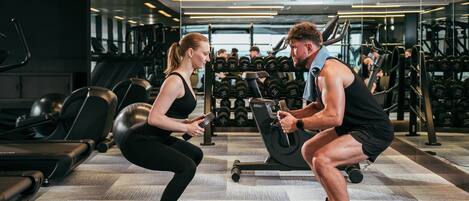 A gym with treadmills, dumbbells, and weight machines.