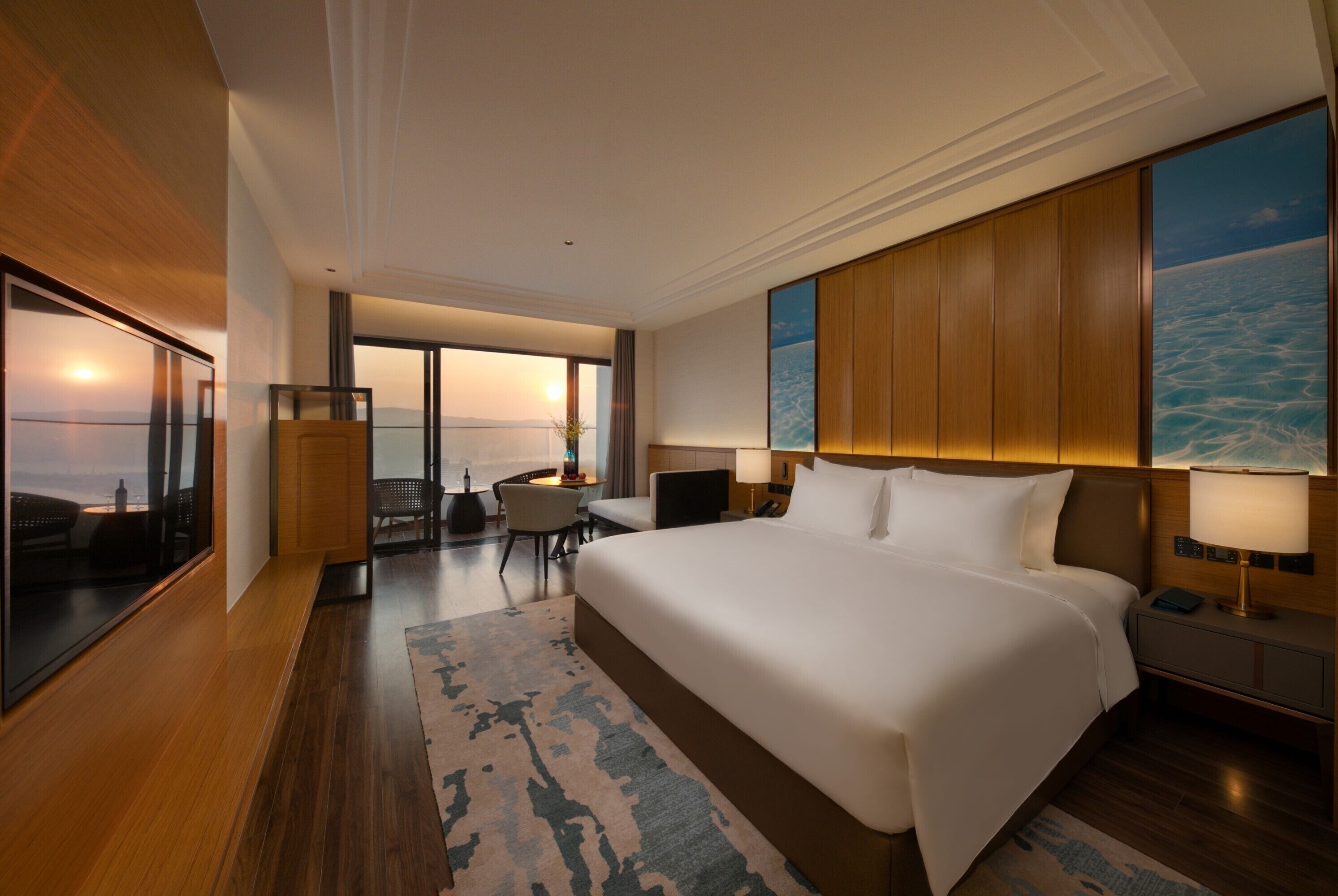 A spacious hotel room with a large bed, a desk, and a view of the ocean.