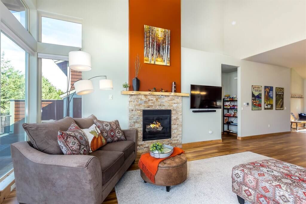 Una sala de estar moderna con chimenea, un sofá y una televisión.